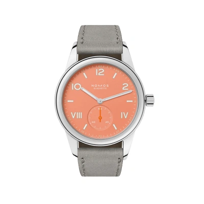 Die NOMOS Club mit cream coral Zifferblatt und wei&szlig;en Indizes ist mit einem grauen Veloursleder ausgestattet. Minuten- und Sekundenziffern in Weiss verbessern die Ablesbarkeit. Kleine Sekunde bei 6 Uhr, Geh&auml;use aus Edelstahl, sportlich-elegantes Design.