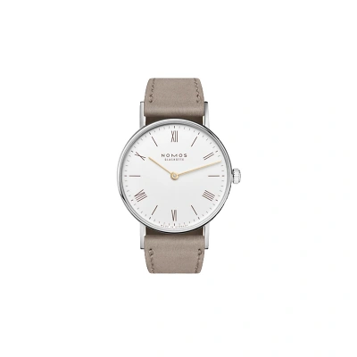 Nomos Ludwig mit weissem Zifferblatt, beigen r&ouml;mischen Zahlen &  Indizes, goldigen Zeigern. Superluminova-Beschichtung. Kleine Sekunde bei 6 Uhr. Edelstahlgeh&auml;use mit anthrazitfarbenem Veloursleder. Armband auf beigem Veloursleder. Elegant Look.
