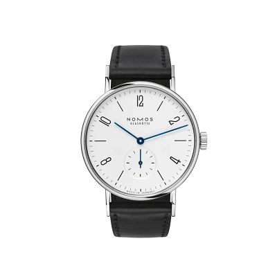 Zu sehen ist die Nomos Tangente mit wei&szlig; versilbertem Zifferblatt. Schwarze Strichindizes und arabische Zahlen markieren die Stunden. Die Zeiger sind in Vergissmeinnicht-Blau, der Sekundenzeiger ist dezentral. Das Band ist schwarz aus Horween Leder.